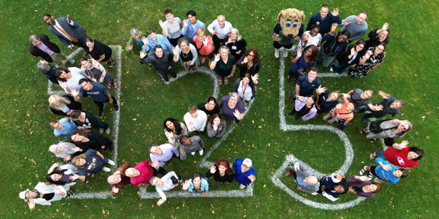 BU community members standing within the numbers 125 painted on the grass